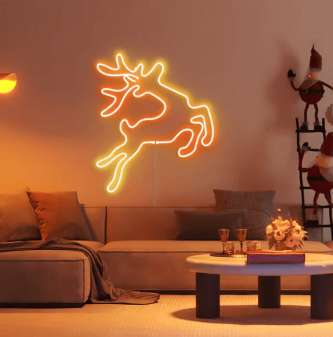 Woonkamer met neon LED-muurdecoratie in de vorm van een rendier, sfeervolle kerstverlichting in warme oranje tinten
